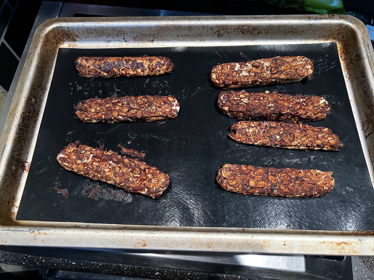 asian marinated tempeh slices on a lined baking sheet.