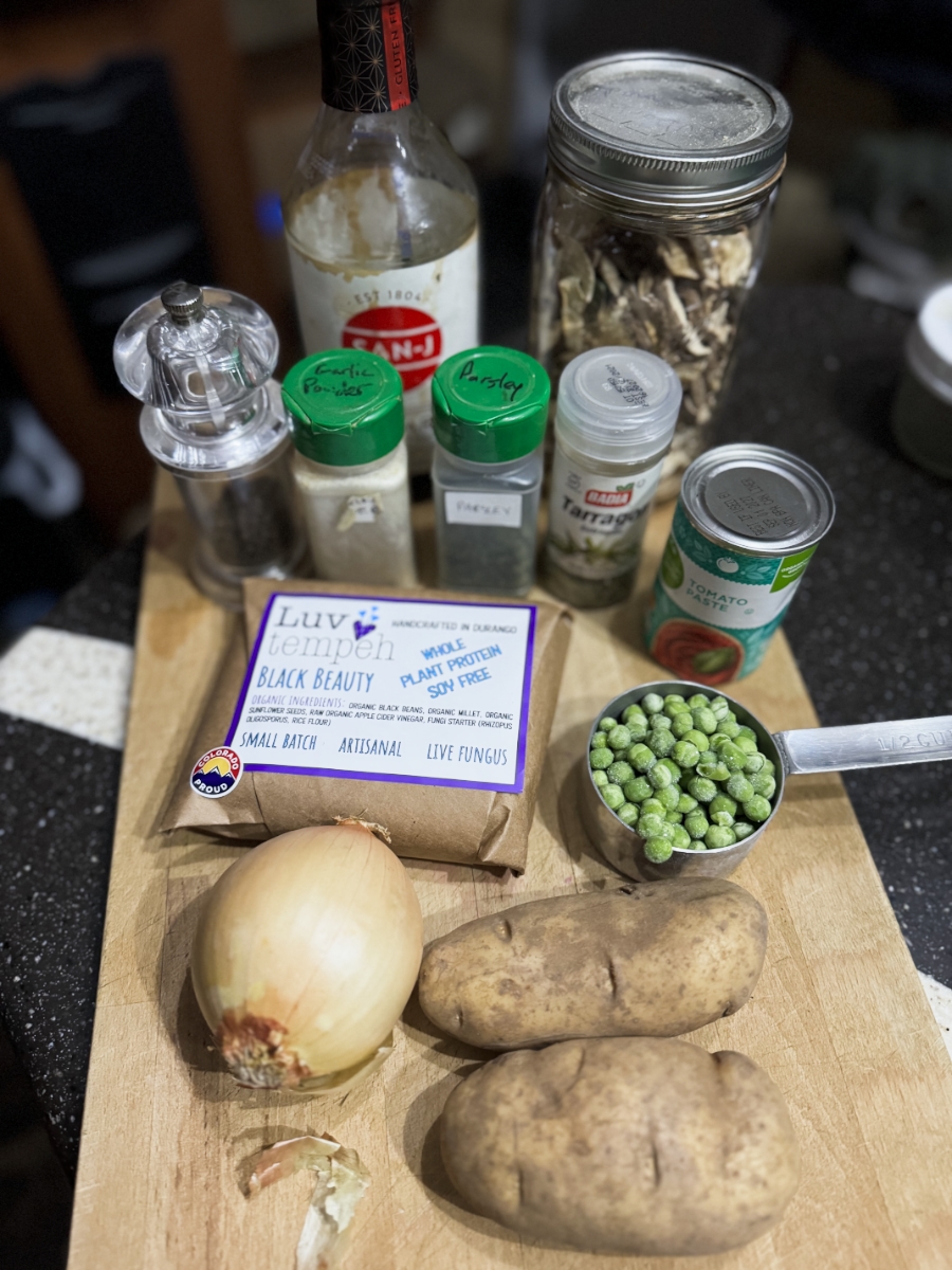 hearty vegan stew ingredients on a wooden cutting board.