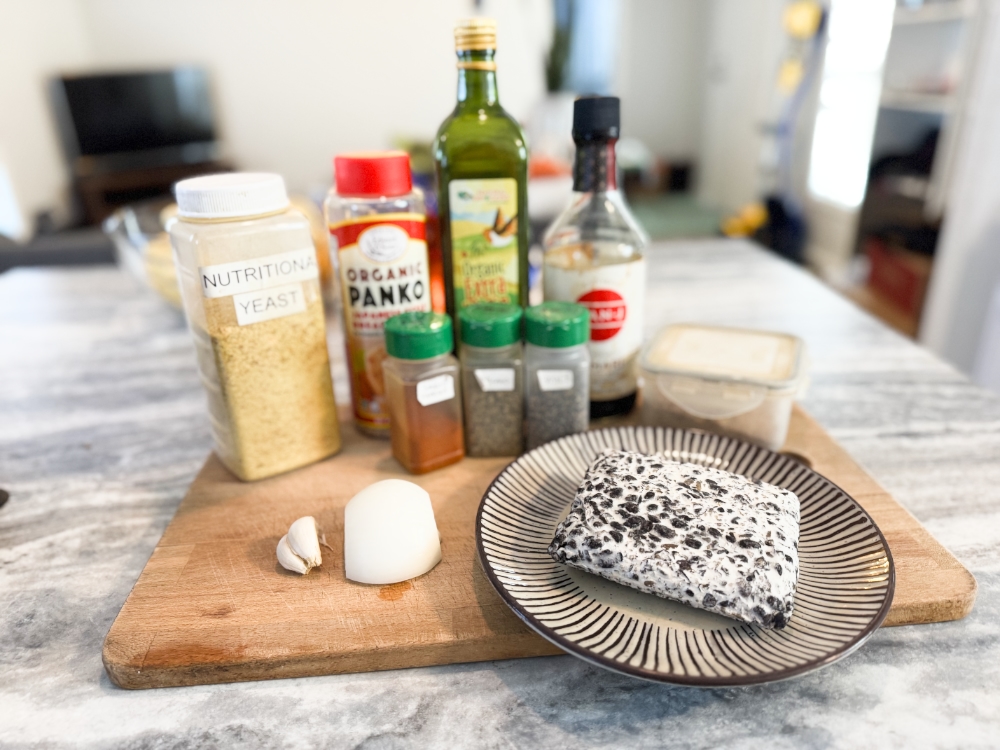 ingredients for tempeh meatballs on a wooden cutting board.