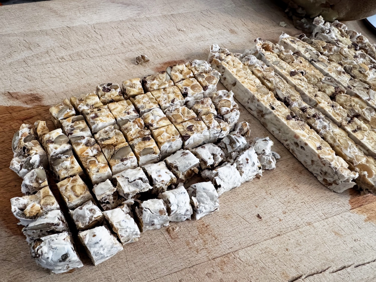 chopping up tempeh on a wooden cutting board.