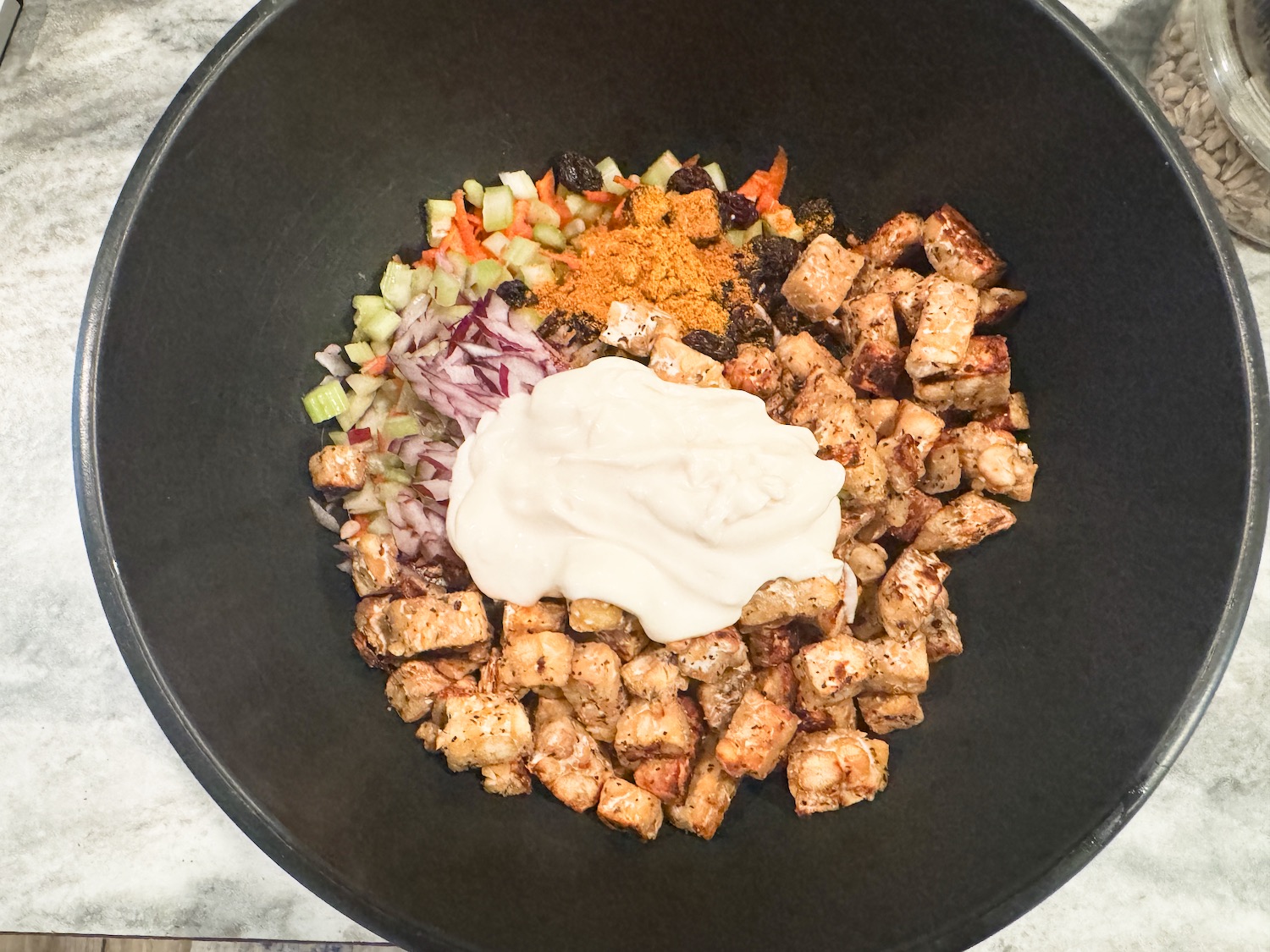 curried tempeh salad recipe ingredients in a bowl before mixing.
