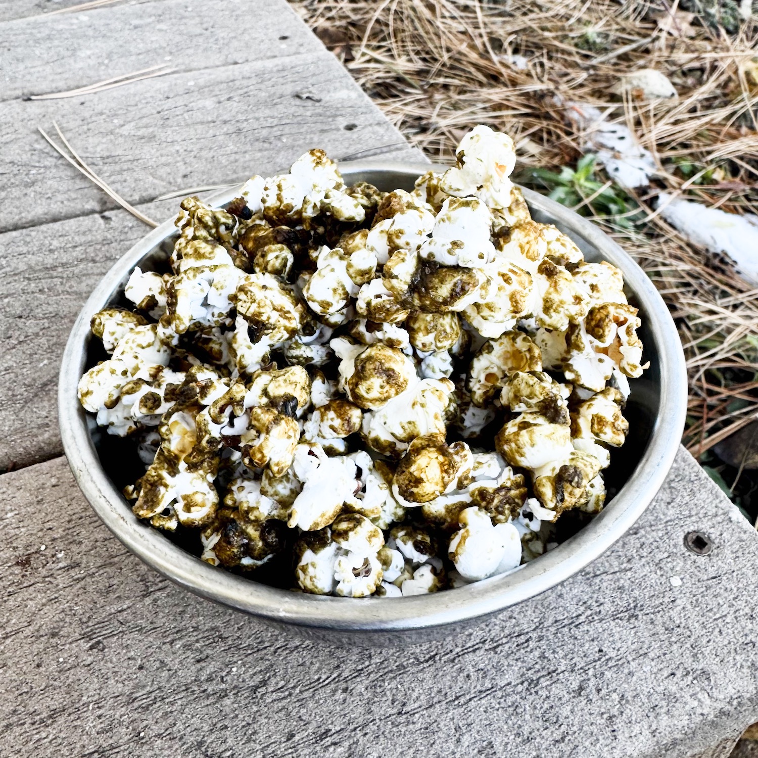 miso black sesame caramel corn in a stainless steel bowl.